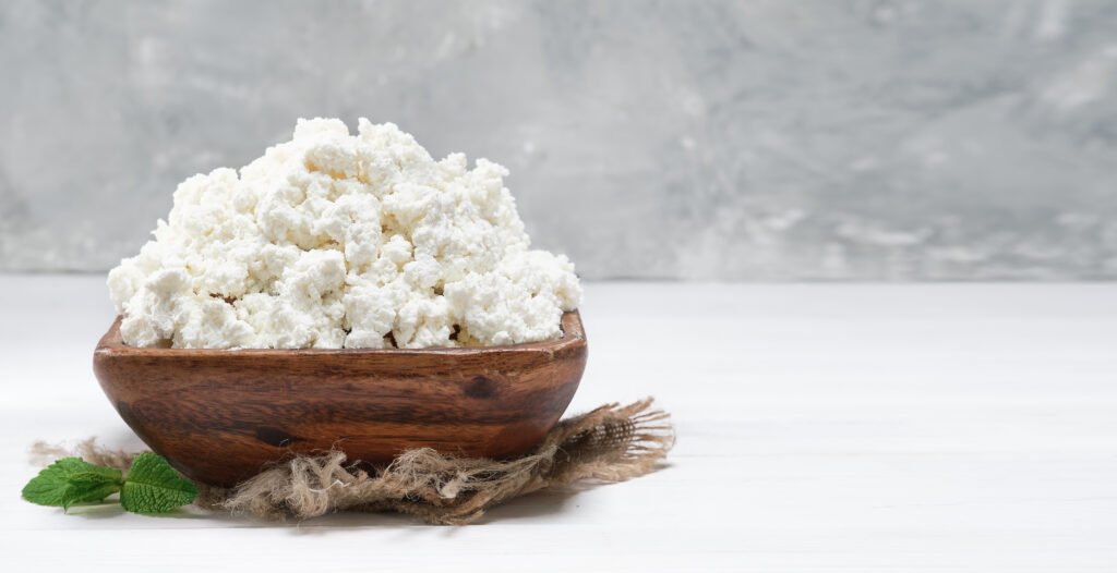 cottage cheese traditional wooden bowl white wooden background close up selective focus with copy space soft curd natural healthy food wholesome diet food Ricotta Cheese for Dogs